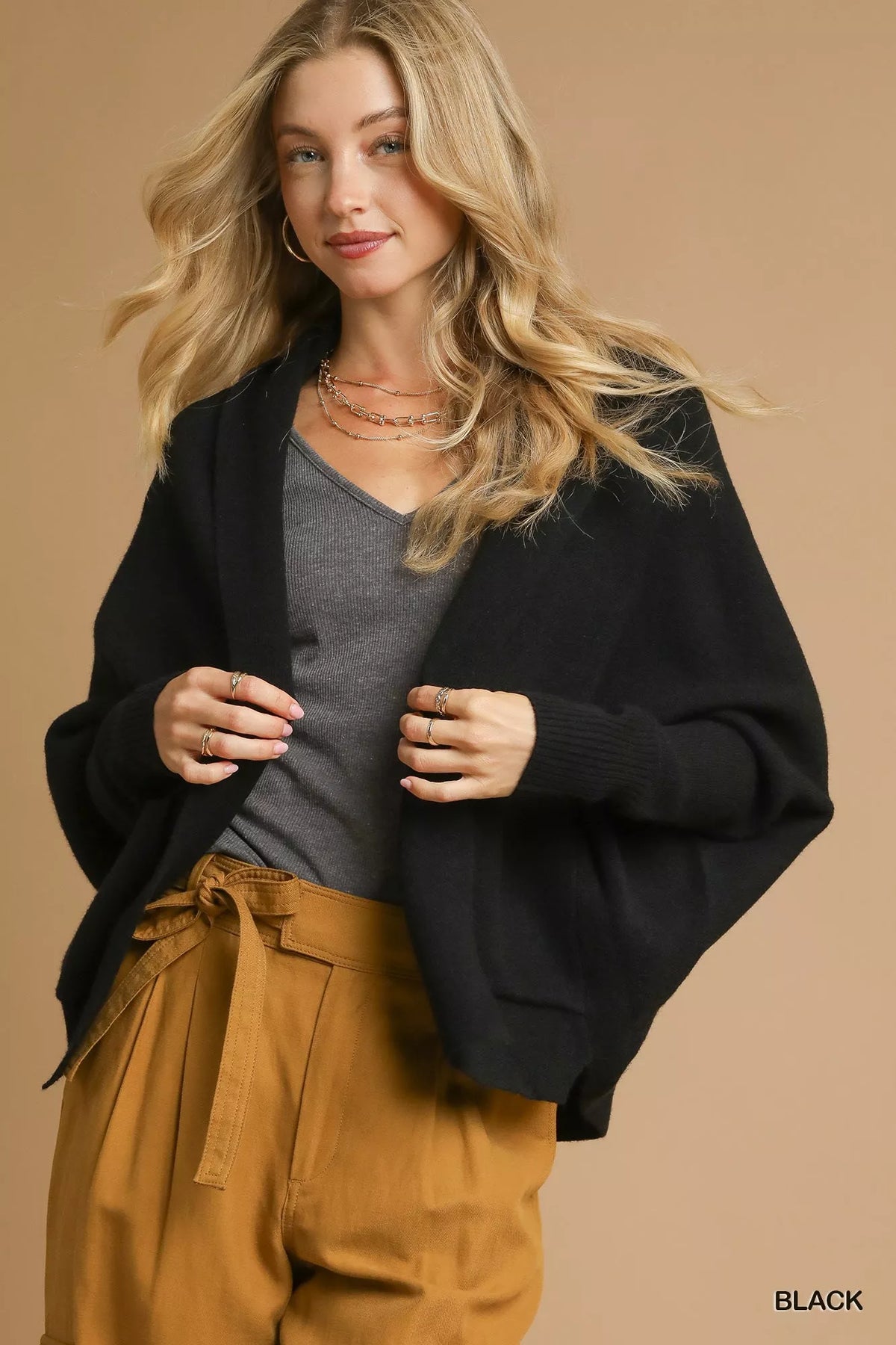 Front view of the black Umgee open-front cardigan with a shawl collar and front pockets, styled over a top and trousers.