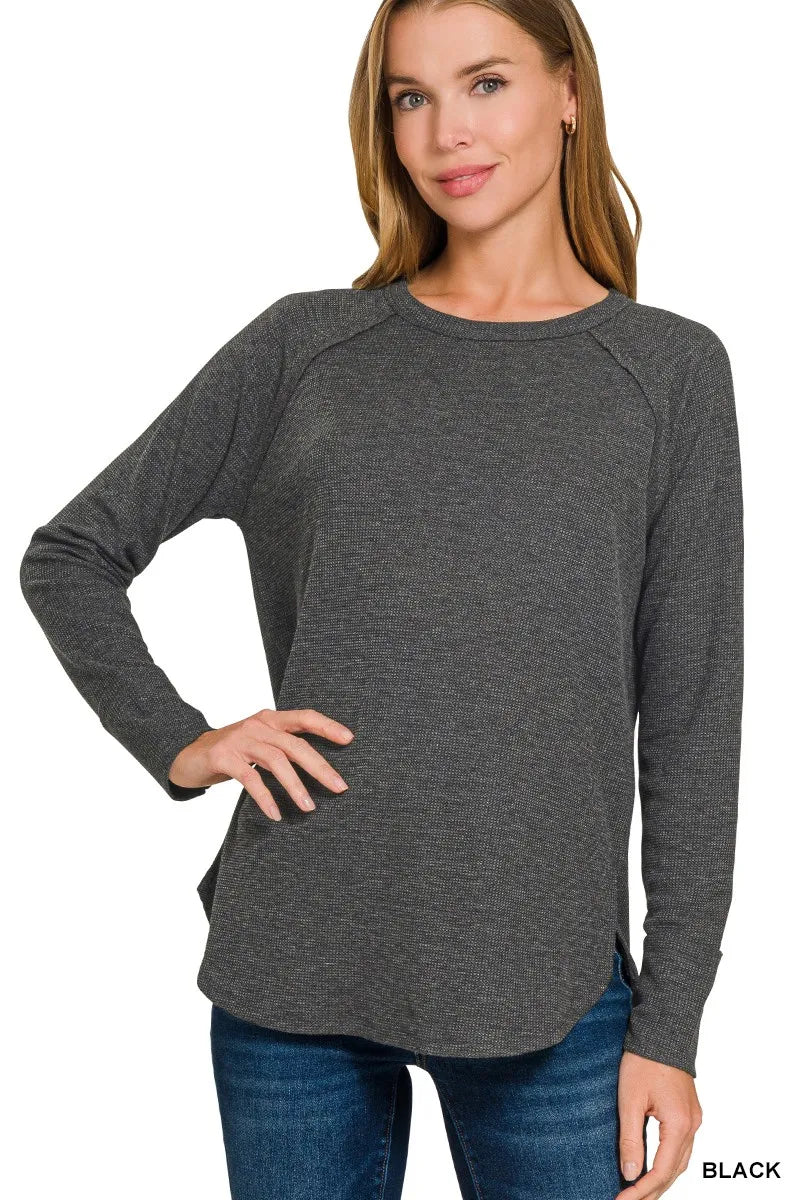 Black Zenana waffle-knit long sleeve top with crew neck and curved hem, model angled view