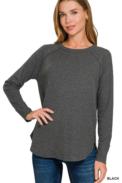 Black Zenana waffle-knit long sleeve top with crew neck and curved hem, model angled view