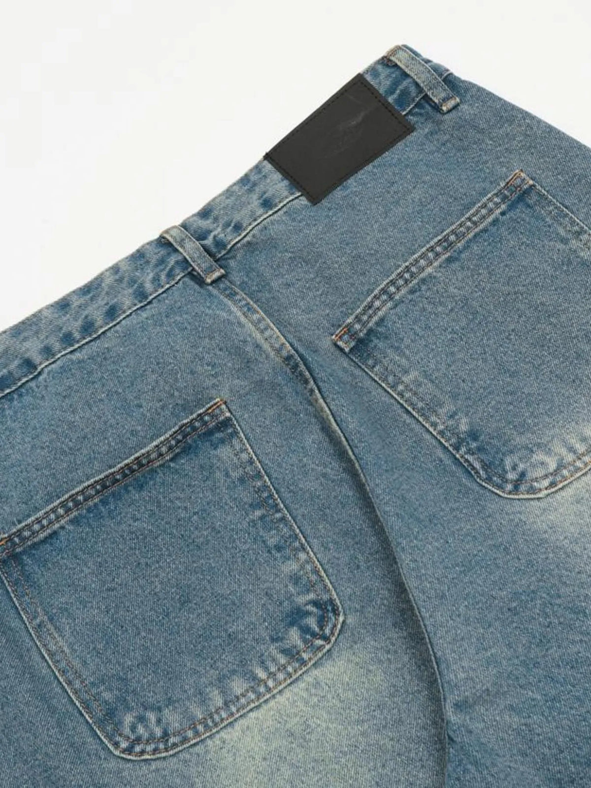 Detailed rear view of the jeans two patch pockets, centre seam and waistband patch.