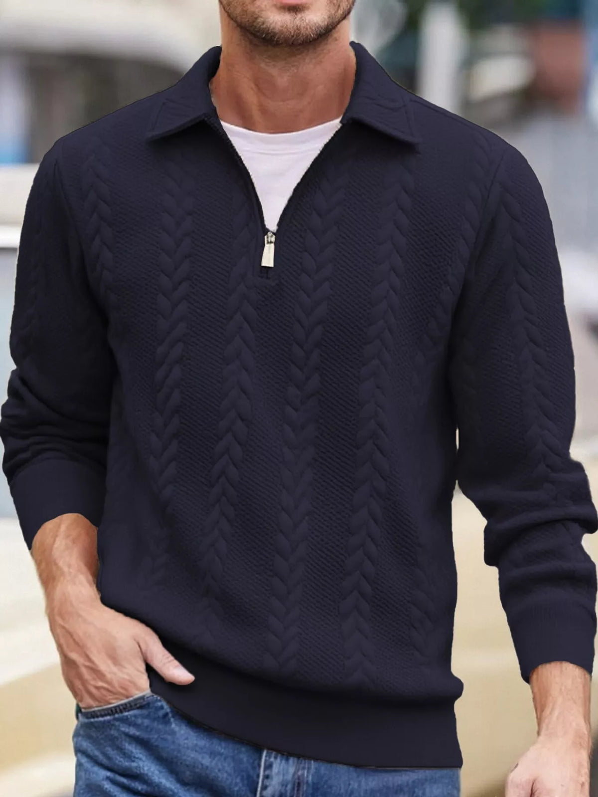 Men's navy cable-textured quarter-zip pullover with pointed collar and ribbed cuffs and hem, shown on a model.