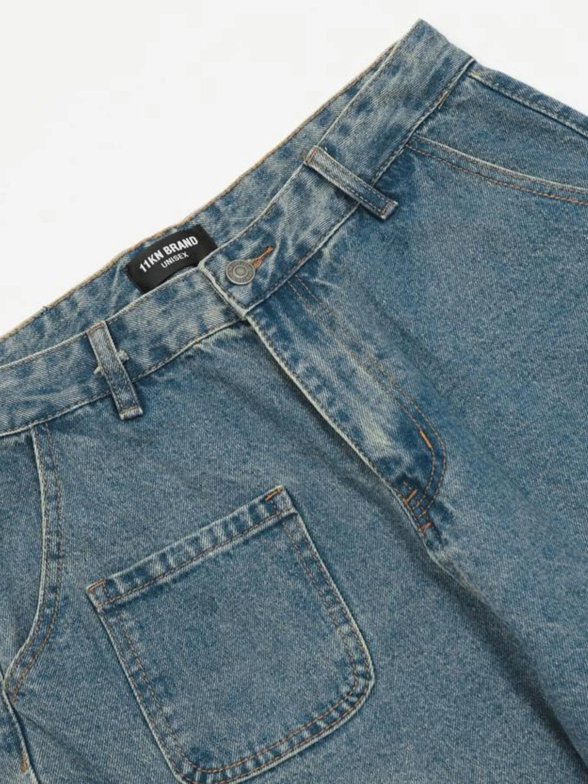 Close-up of the blue cargo jeans front waistband, belt loops and patch pocket.