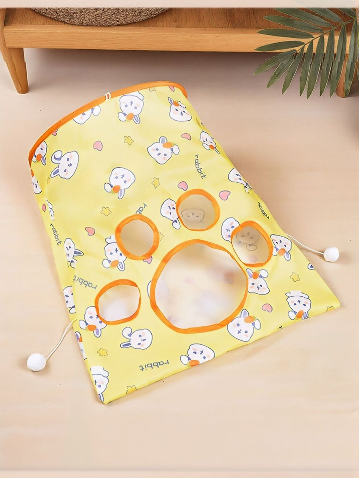 Yellow rabbit-print cat tunnel panel laid flat with round openings.