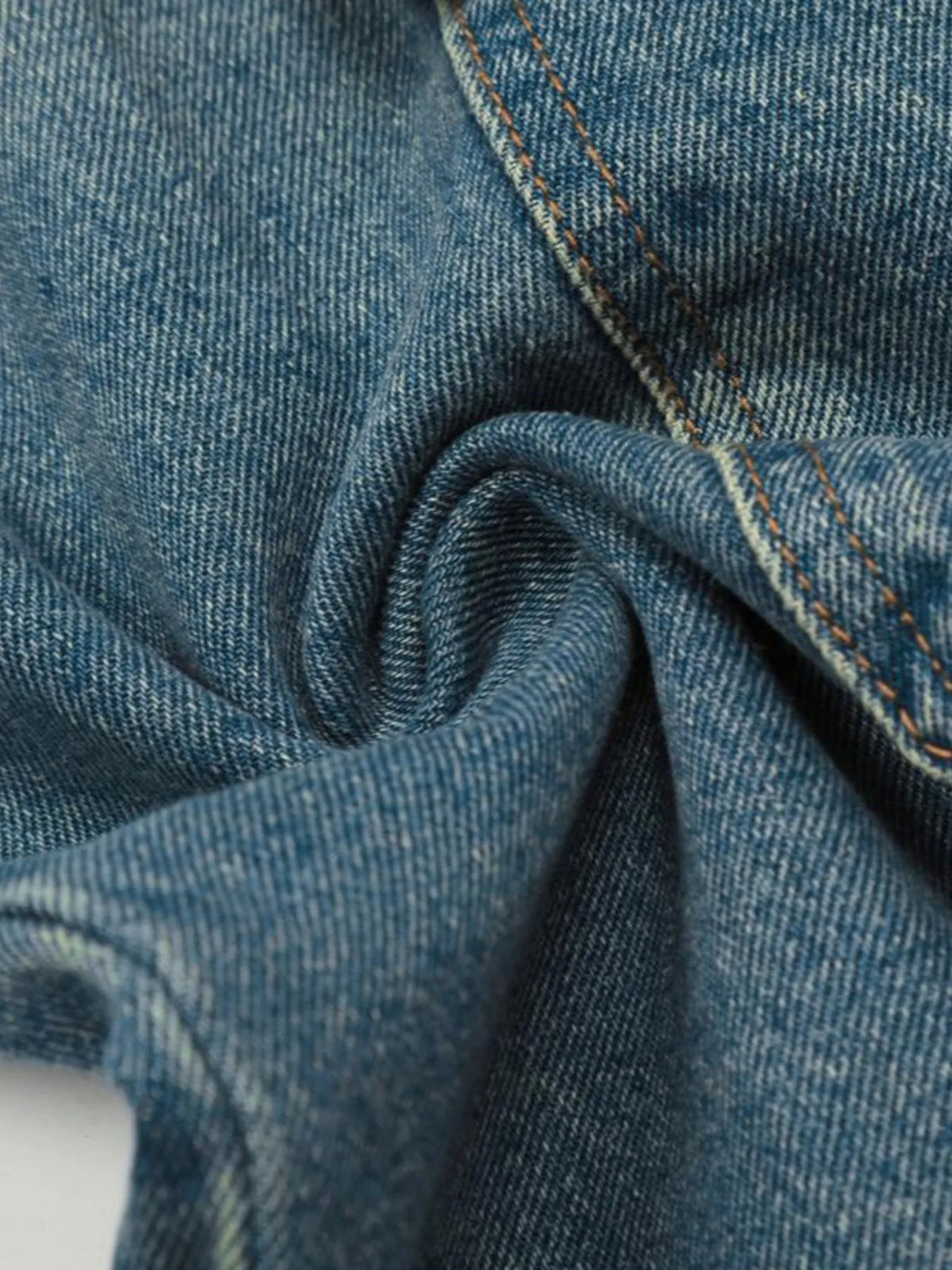 Close-up of blue denim texture and stitching on the cargo jeans.