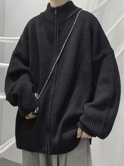 Black ribbed cardigan zipped to the stand collar; the chain and other clothing are not included.