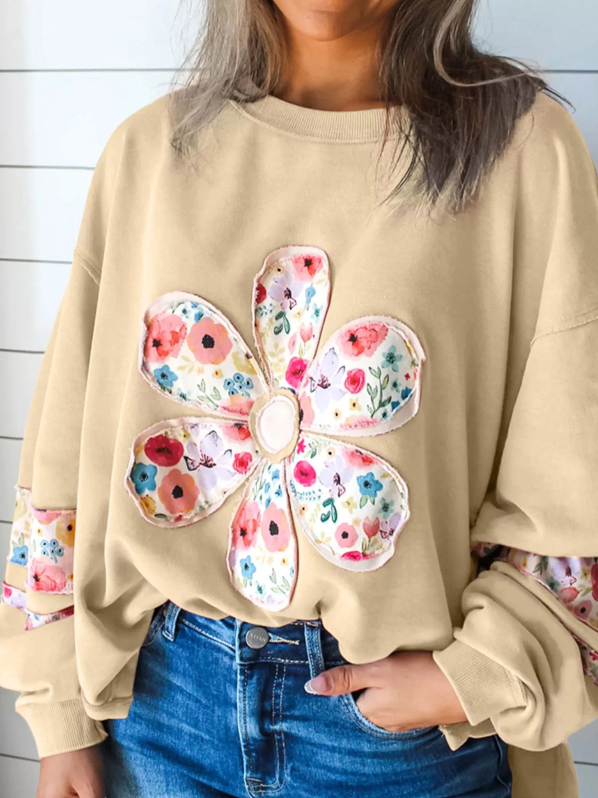 Beige floral applique sweatshirt, front view with round neck and long sleeves. Trousers are styling only.