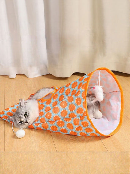 Cat beside an orange circle-print tunnel with a small white ball in the scene.