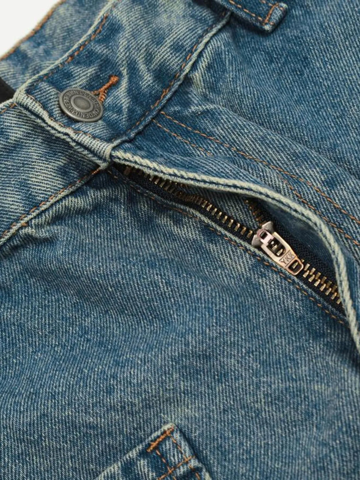 Close-up of the cargo jeans button waistband and open zip fly.