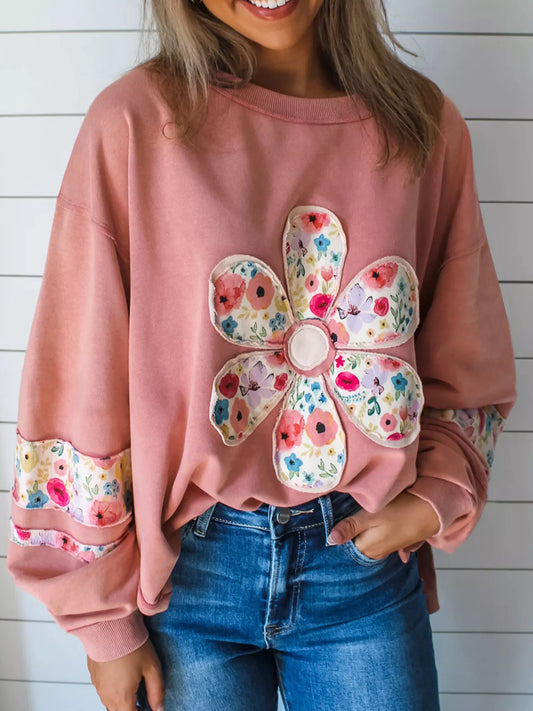 Dusty pink floral applique sweatshirt, front view with round neck and long sleeves. Trousers are styling only.