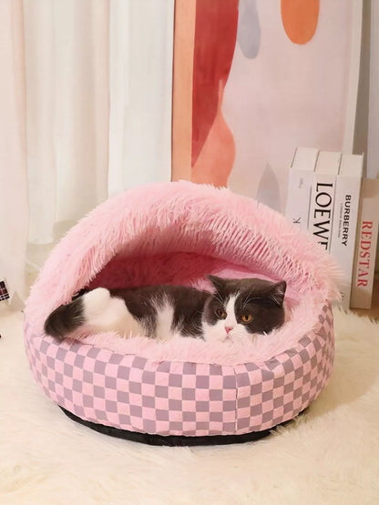 Pink checkerboard covered pet nest with a cat resting inside.