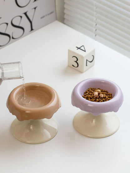 Camel-and-white and lavender-and-white elevated bowls shown with water being poured.