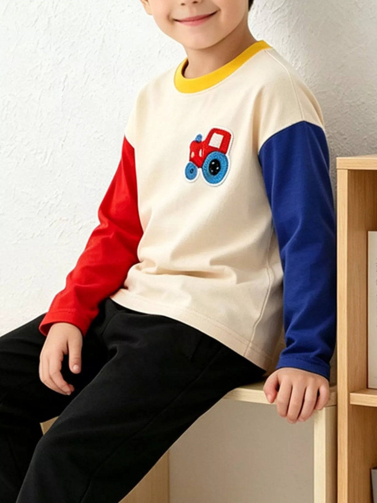 Side view of the cream tractor applique sweatshirt with contrasting sleeves; trousers are not included.