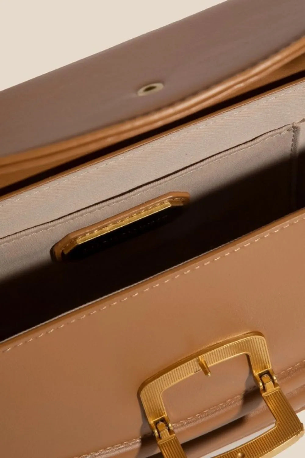 Camel crossbody bag open to show interior and flap fastening