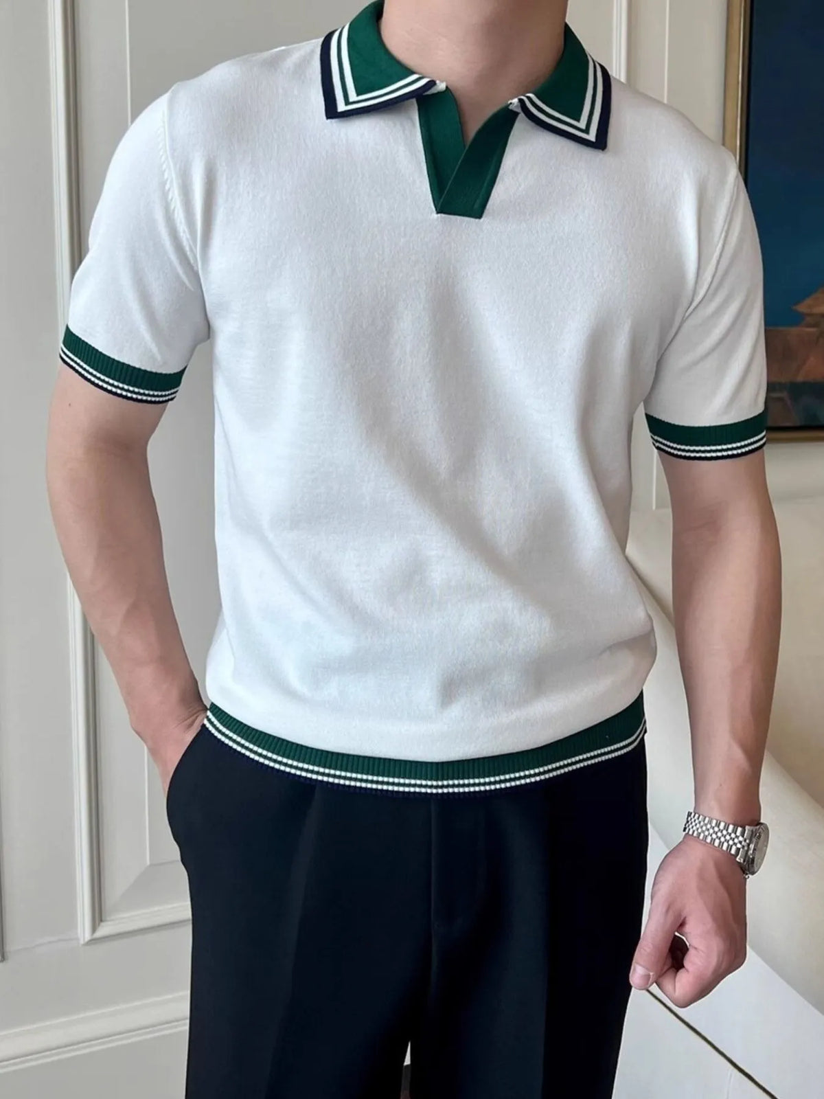 Angled front view of the White polo with dark green and navy striped trim.