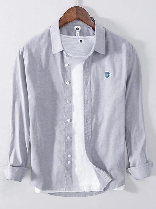 Men's grey long-sleeve button-up shirt, front view styled over a white undershirt
