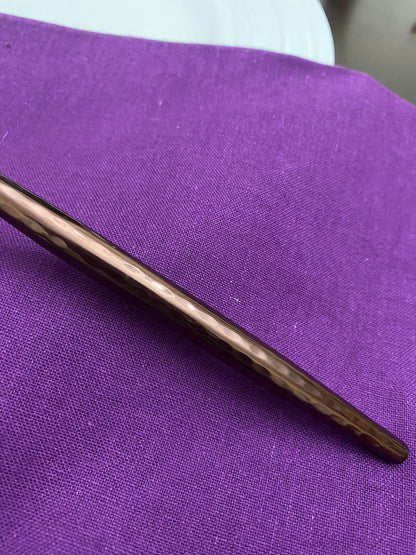 Close-up of the hammered brown handle on a Vibhsa stainless steel soup spoon