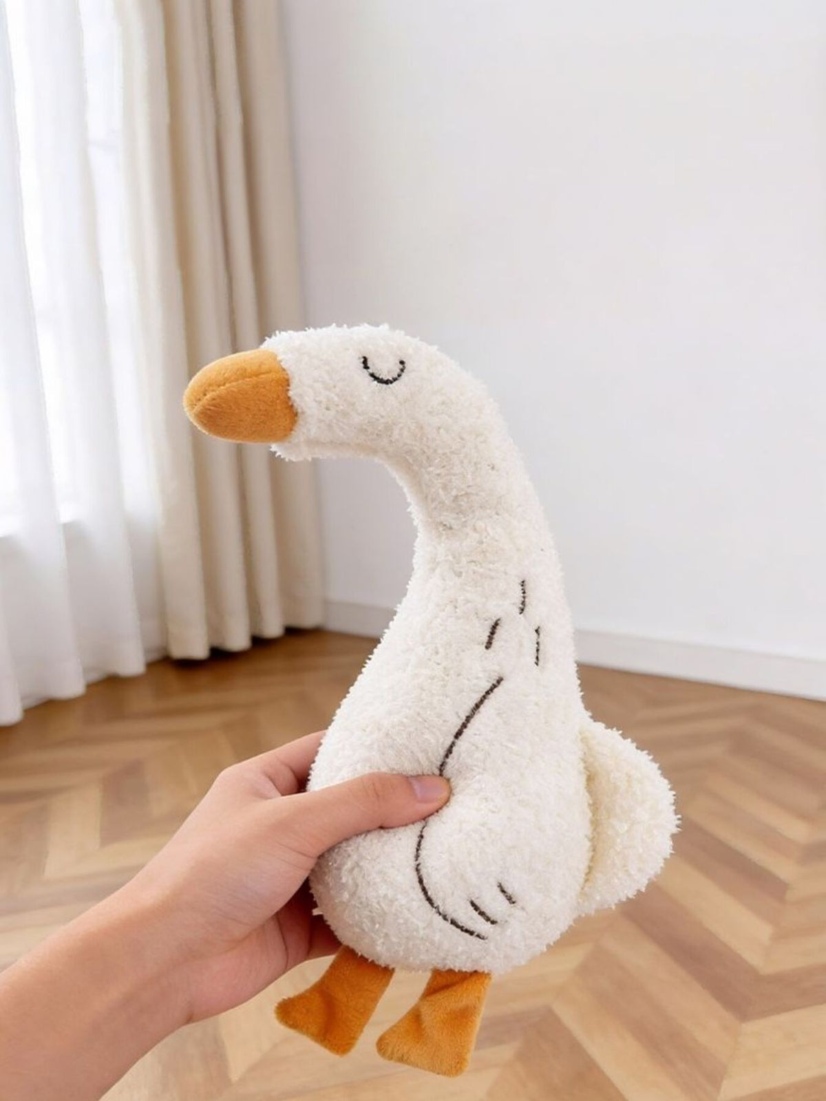 Duck-design plush toy held in a hand