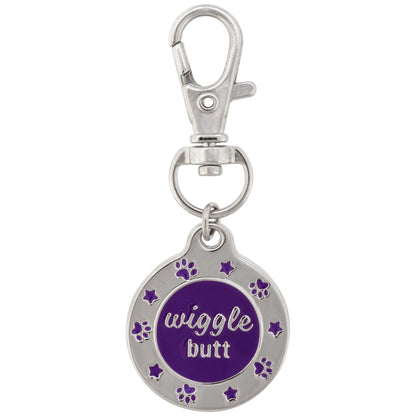 Front of the purple Wiggle Butt enamel pet tag with paw-print and star details and its attached metal clasp.