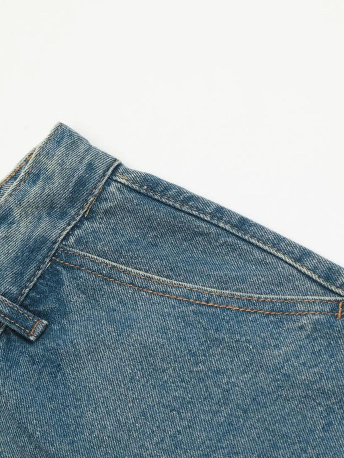 Close-up of the slanted front pocket opening and belt loop on blue cargo jeans.