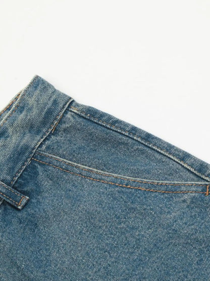 Close-up of the slanted front pocket opening and belt loop on blue cargo jeans.