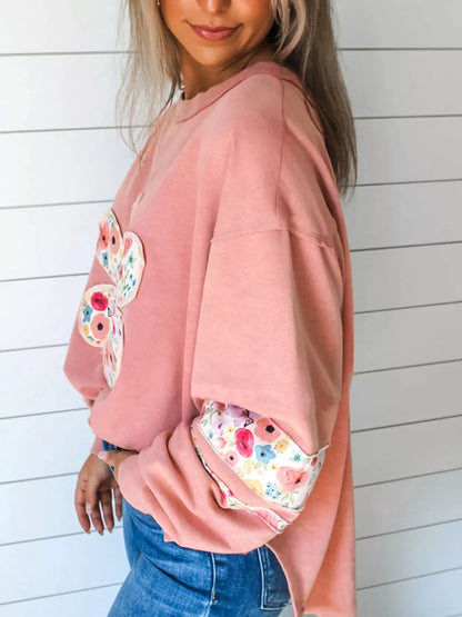 Dusty pink floral applique sweatshirt, side view with drop shoulder and sleeve patch.
