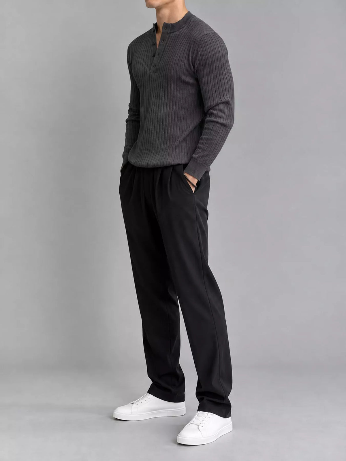 Dark gray ribbed long-sleeve knit top with button detailing, modelled angled front view. One top only; styling pieces not included.