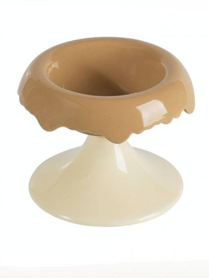 Camel-and-white elevated ceramic pet bowl shown empty.