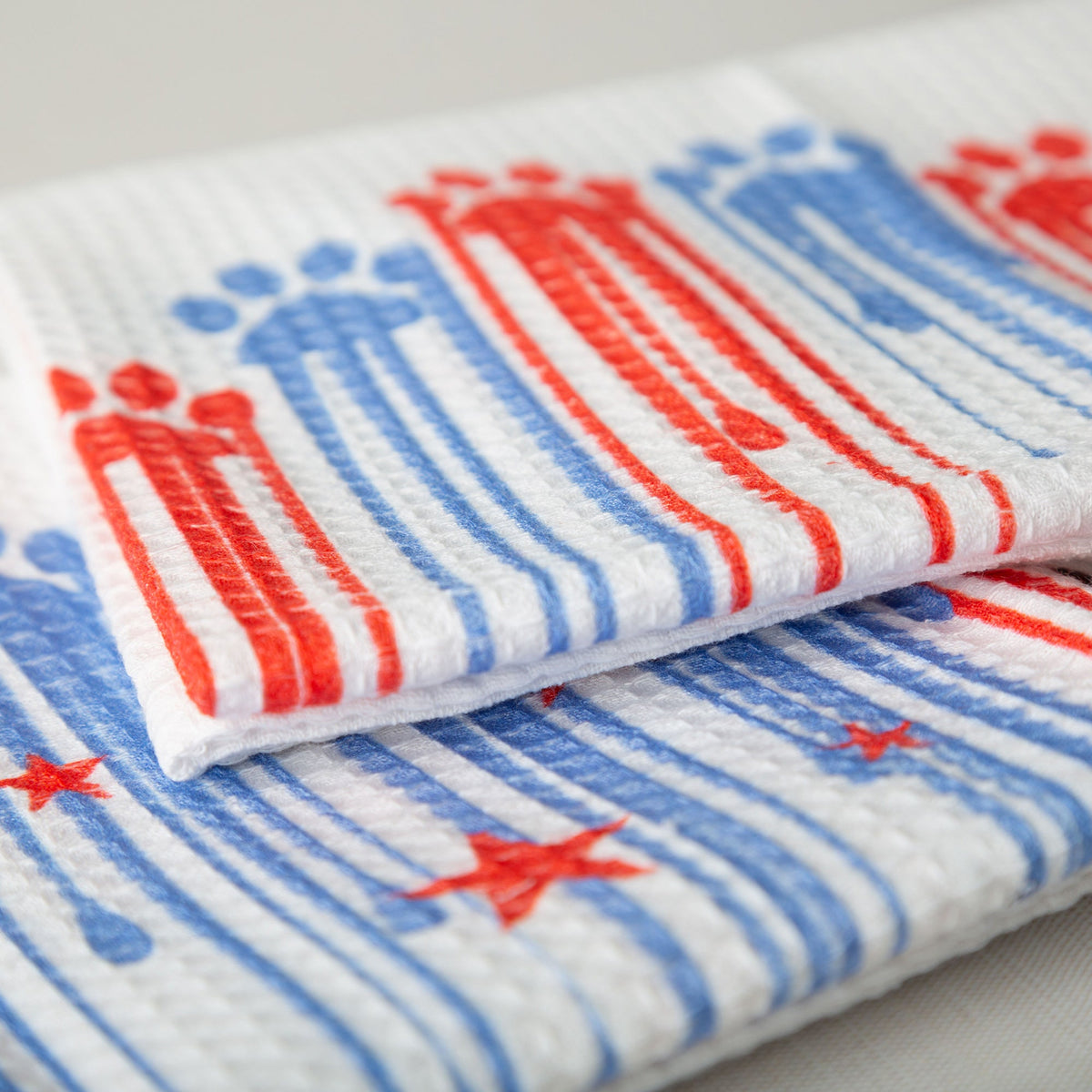 Close-up of the red and blue Painted Paws towel print.