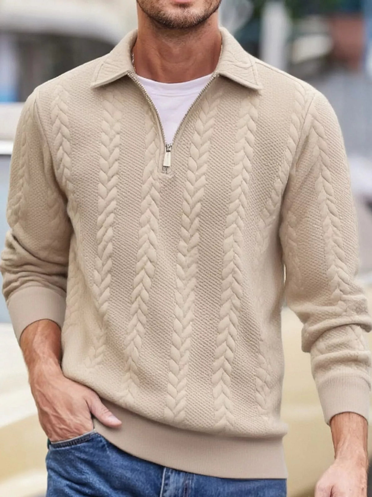 Men's beige cable-textured quarter-zip pullover with pointed collar and ribbed cuffs and hem, shown on a model.