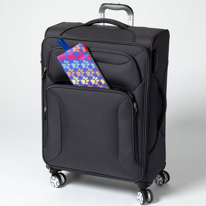 Folded Diagonal Paws backpack beside a rolling suitcase; suitcase not included.