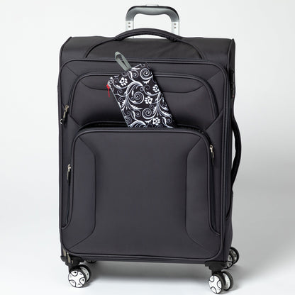 Folded Flourish Paws backpack beside a rolling suitcase; suitcase not included.