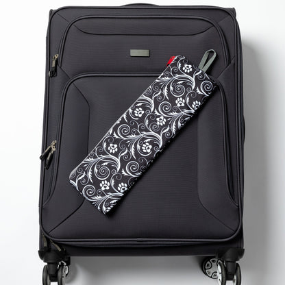 Folded Flourish Paws backpack displayed on a rolling suitcase; suitcase not included.