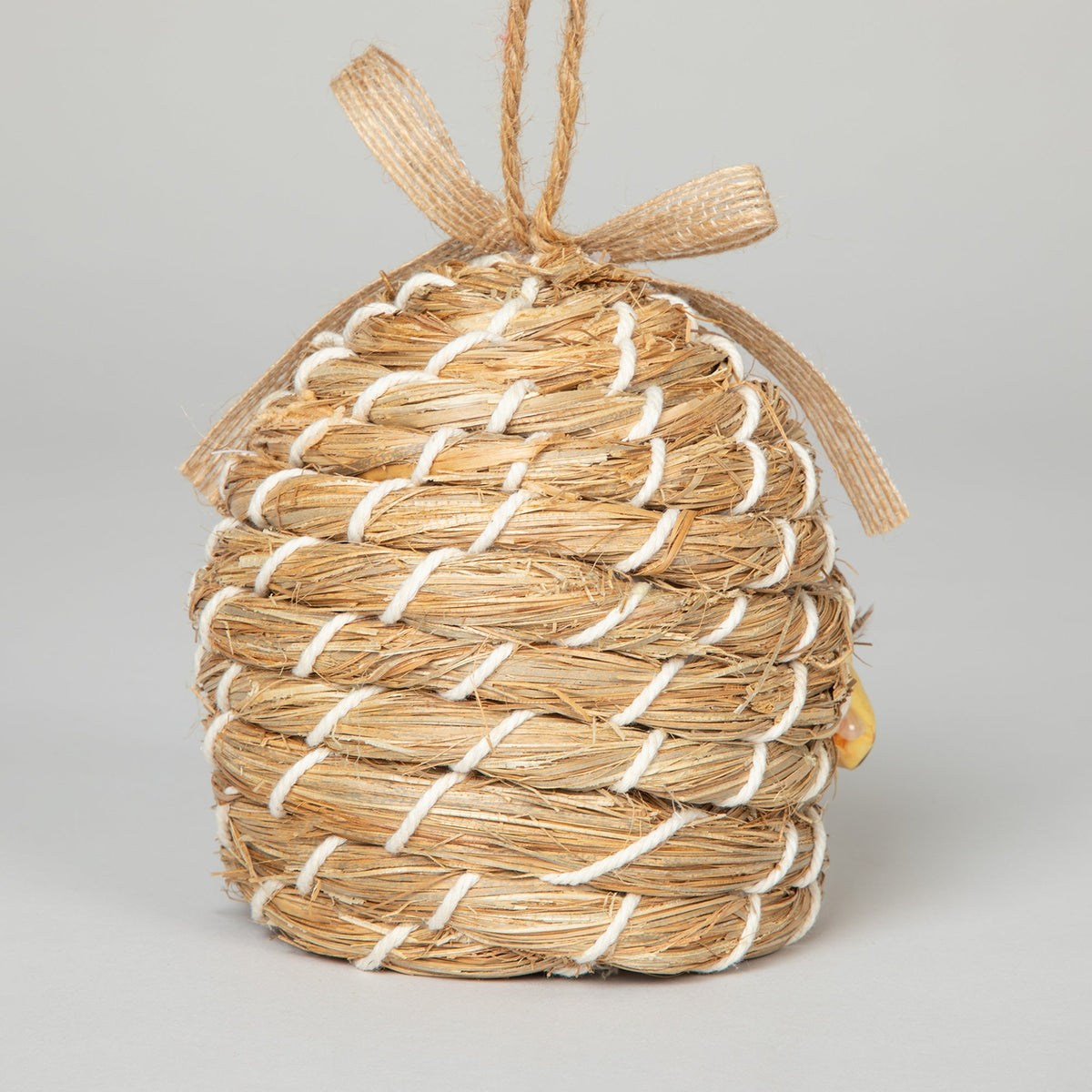 Rear view of the decorative beehive-shaped birdhouse with woven texture.