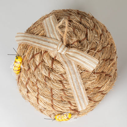 Bottom view of the decorative beehive-shaped birdhouse with ribbon and faux bees.