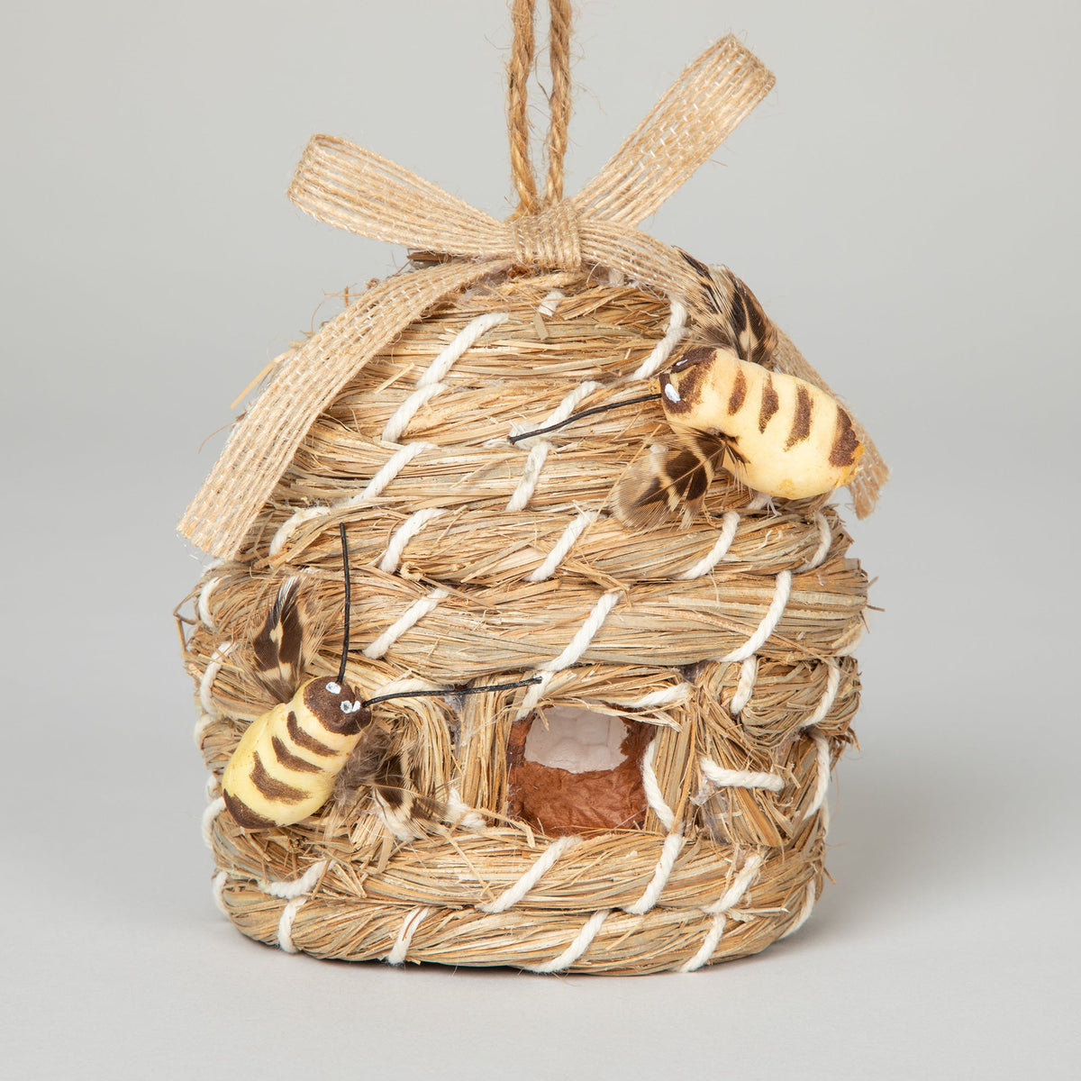 Front view of the decorative beehive-shaped birdhouse with faux bees, ribbon and hanging loop.