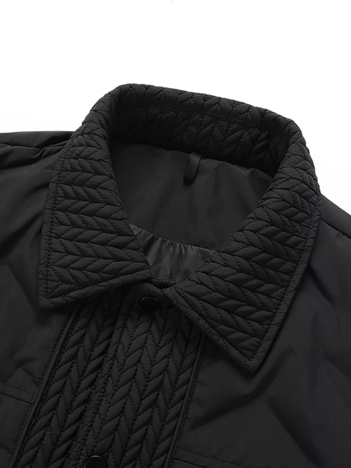Close-up of the black jacket collar and snap placket with quilted edging.