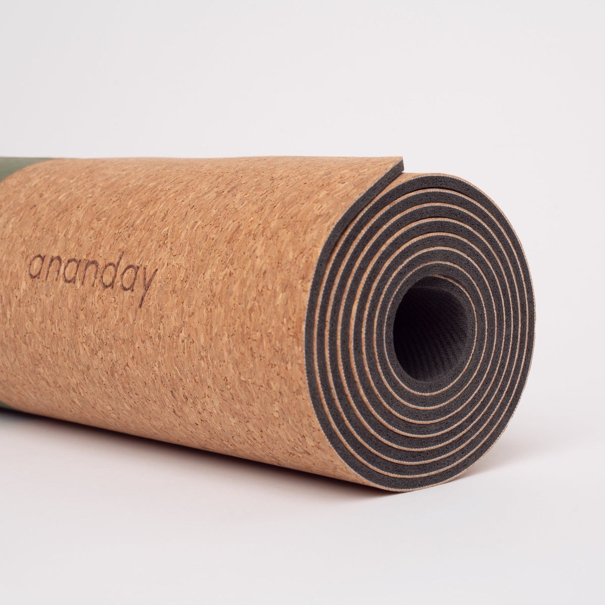 Close-up of the rolled Ananday yoga mat showing its cork surface and dark natural-rubber base.