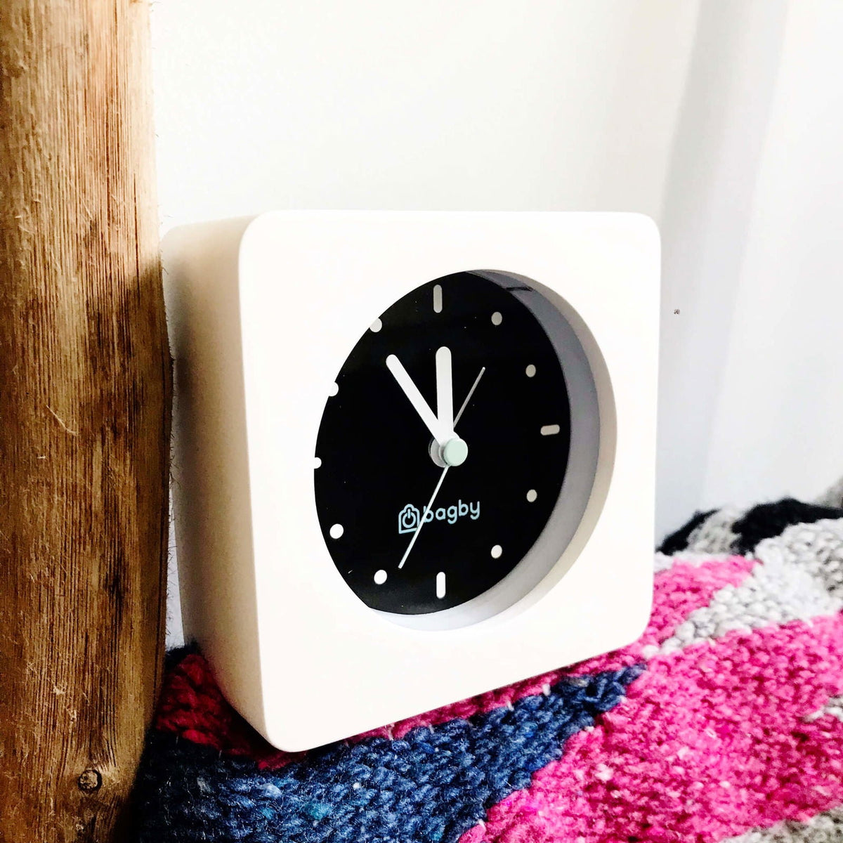 White Bagby MINIMALIST clock beside a blanket