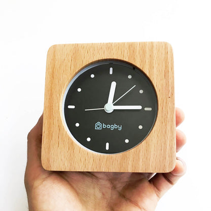 Light-wood Bagby MINIMALIST clock held in a hand