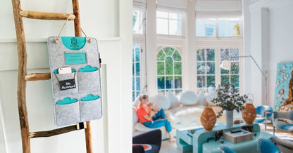 Kitchen scene with a charcoal four-pocket phone organizer hanging near people preparing food.