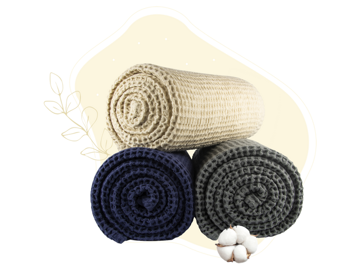 Ivory, blue and gray waffle weave throws shown rolled for color comparison