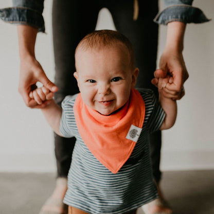 Baby wearing the orange bib from the Estes eight-bib set.