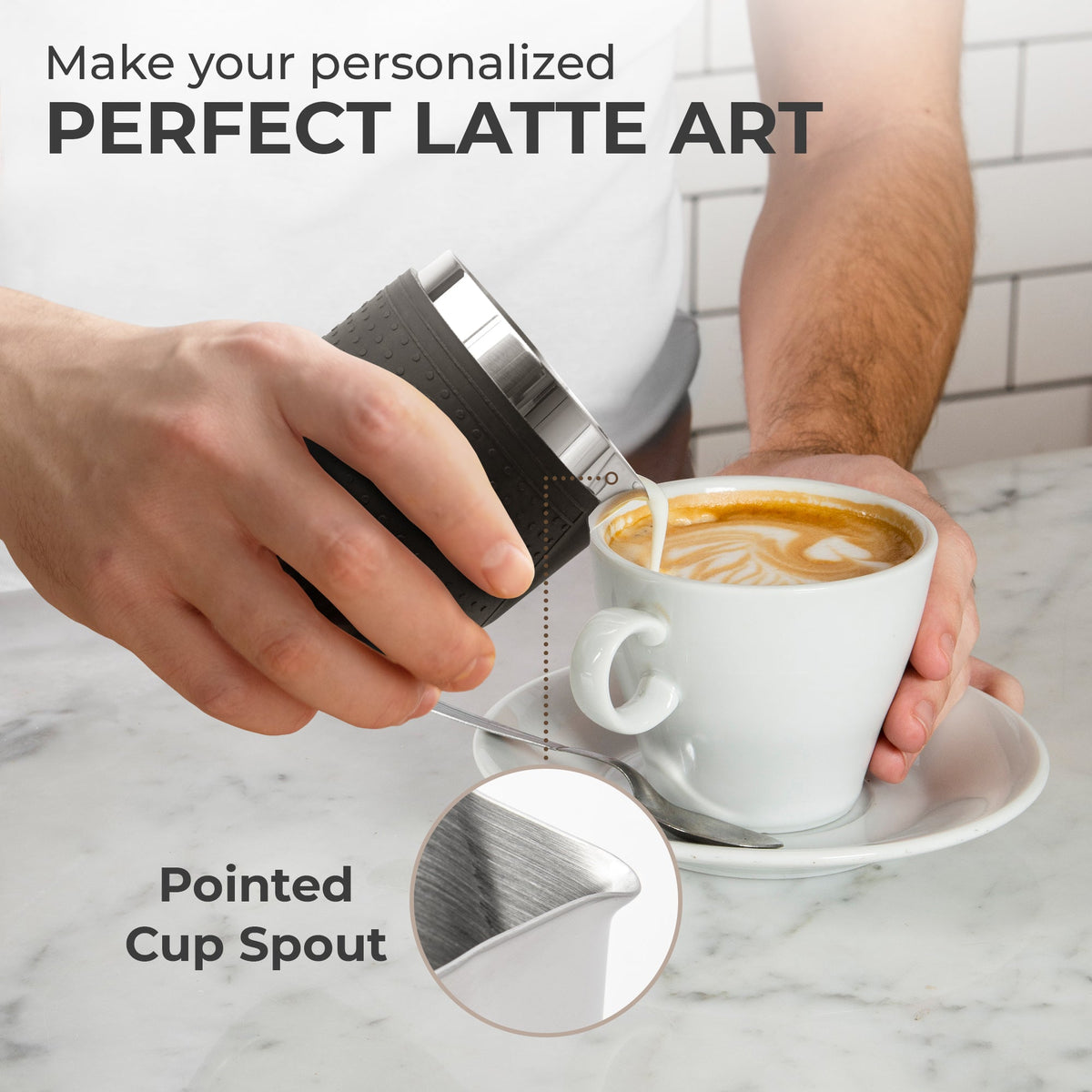 Kaffe milk frothing pitcher pouring latte art into a cup; drinks and cup not included