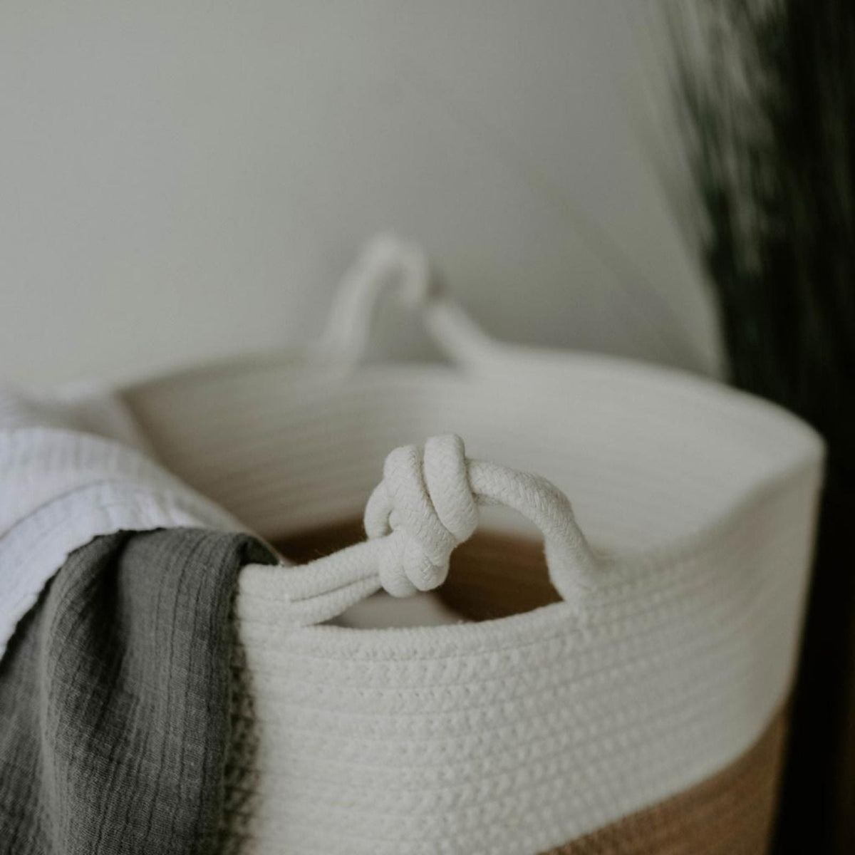 Close-up of a knotted cotton rope handle and the cream basket rim.