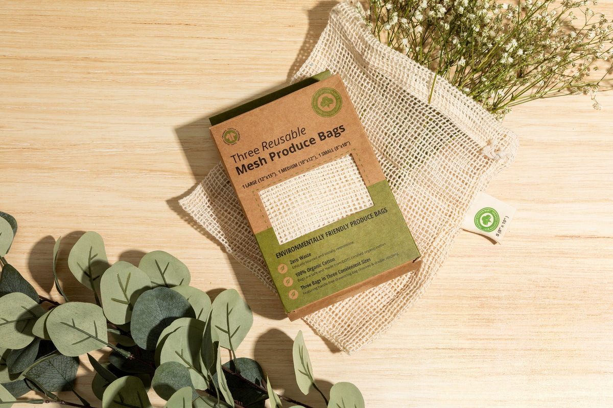 Mesh produce-bag gift box with a mesh bag on a wooden surface; decorative greenery is not included.