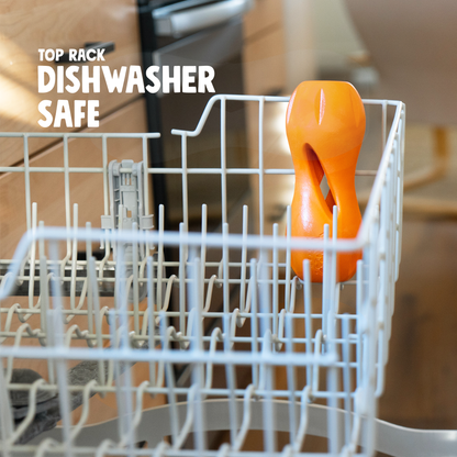 Tangerine West Paw Qwizl toys in a dishwasher rack; graphic says top-rack dishwasher safe.
