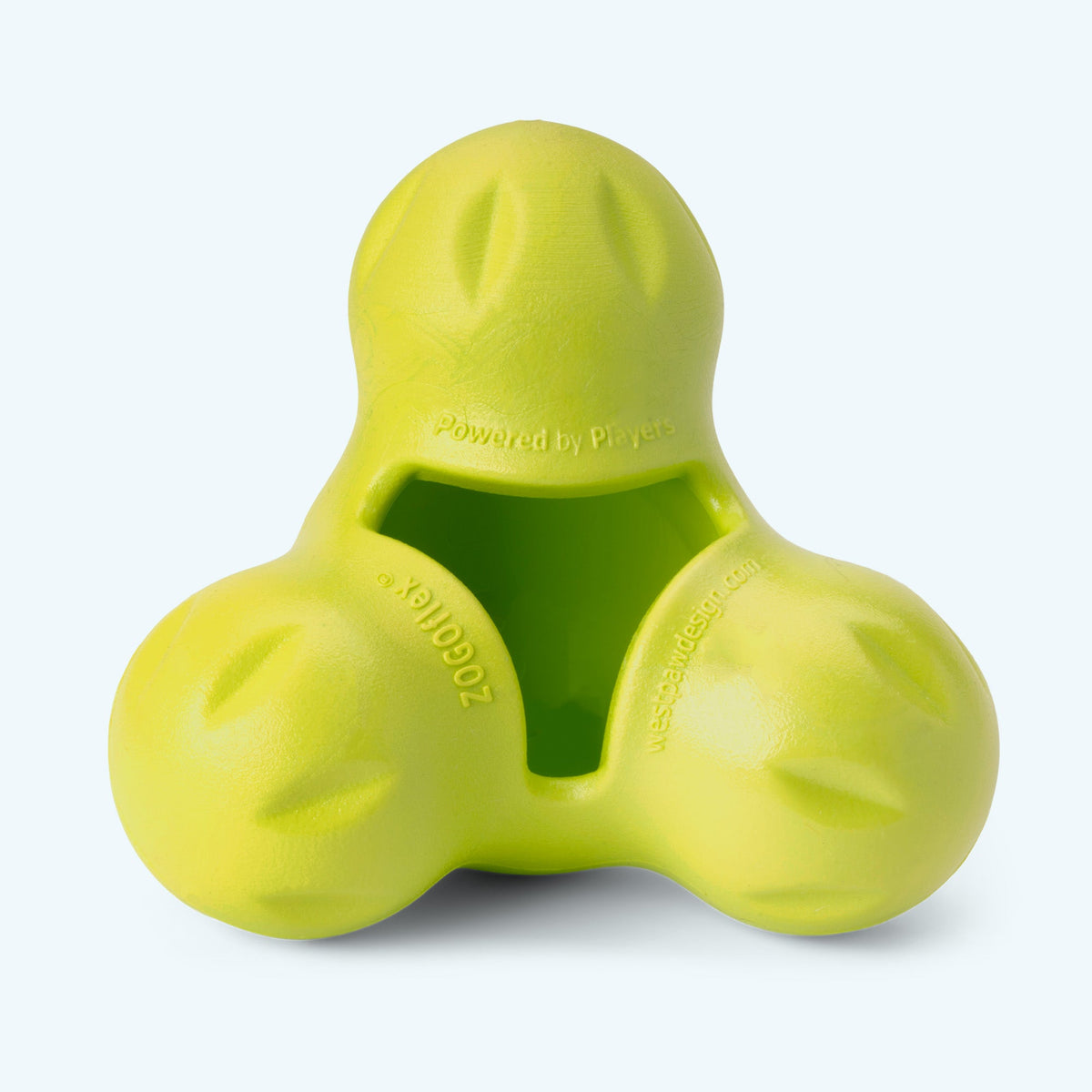 Close-up of a Granny Smith green West Paw Tux treat toy showing the three-lobed shape, shallow cavity and embossed brand marks.
