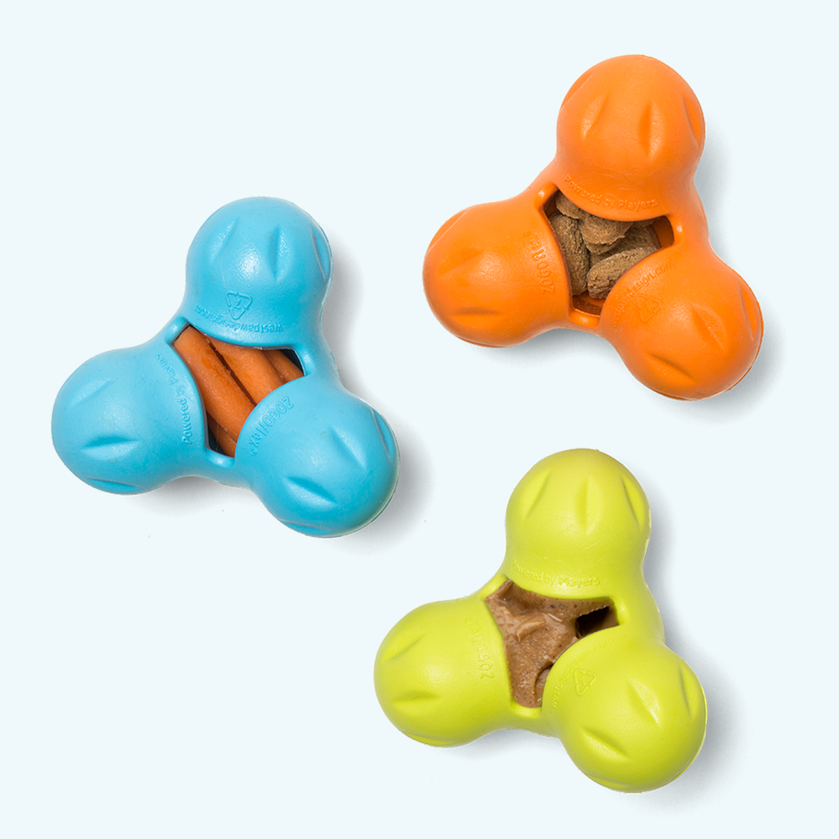 West Paw Tux treat toys in Aqua Blue, Tangerine and Granny Smith green, each with a three-lobed body and central treat cavity.