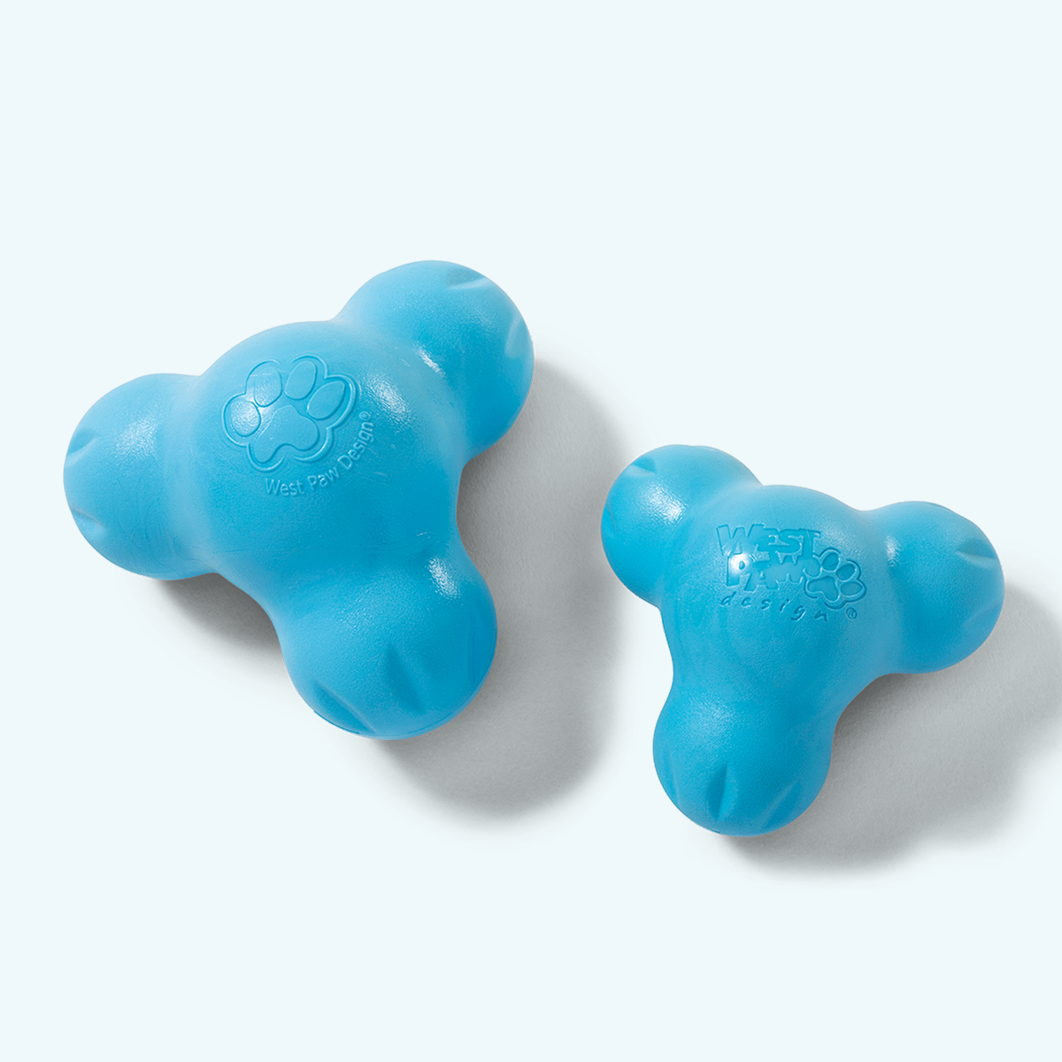 Two Aqua Blue West Paw Tux treat toys showing their rounded lobes and treat cavities; one toy is included per purchase.