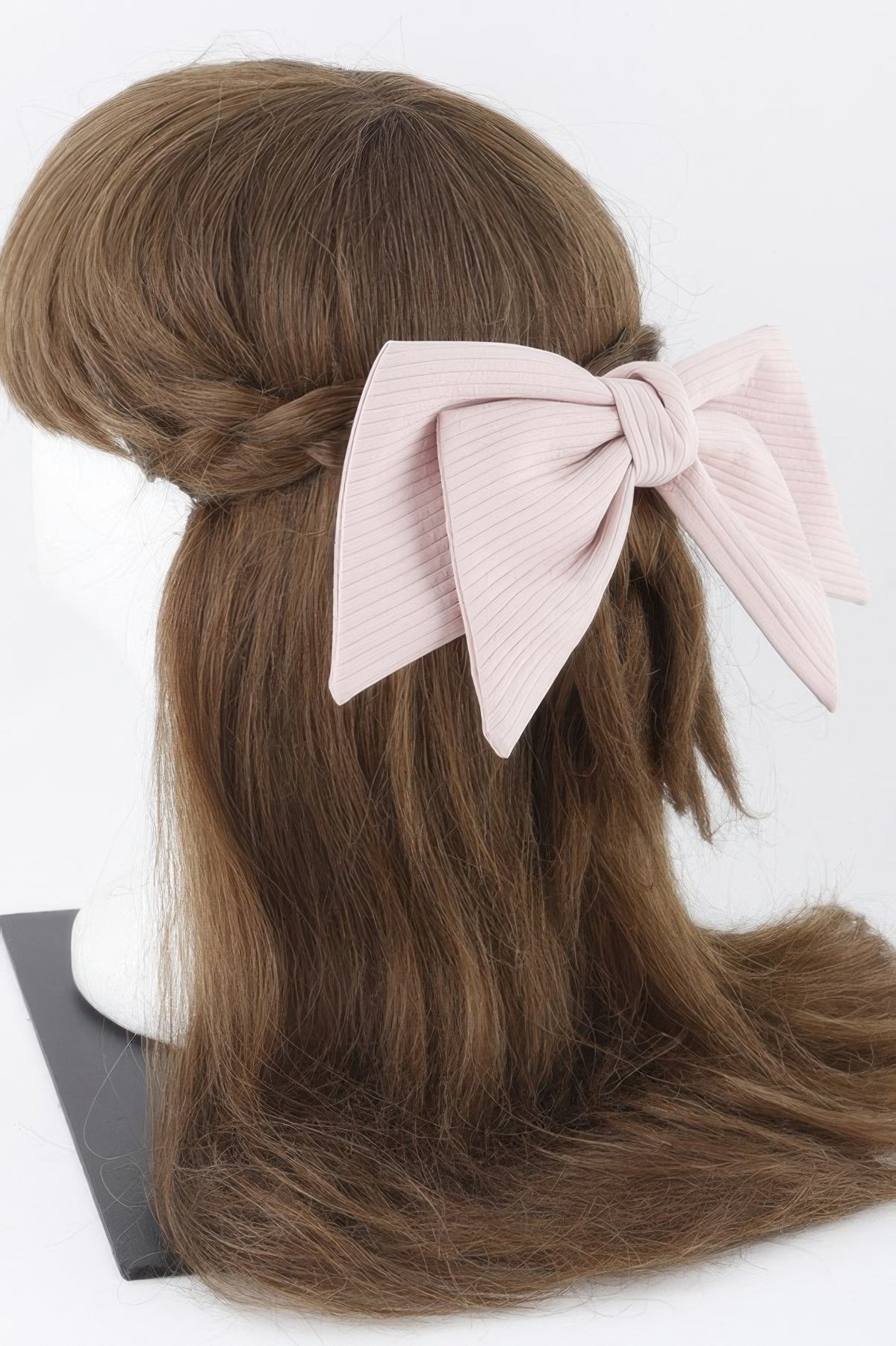 Pink lined ribbon hair clip worn in a half-up hairstyle